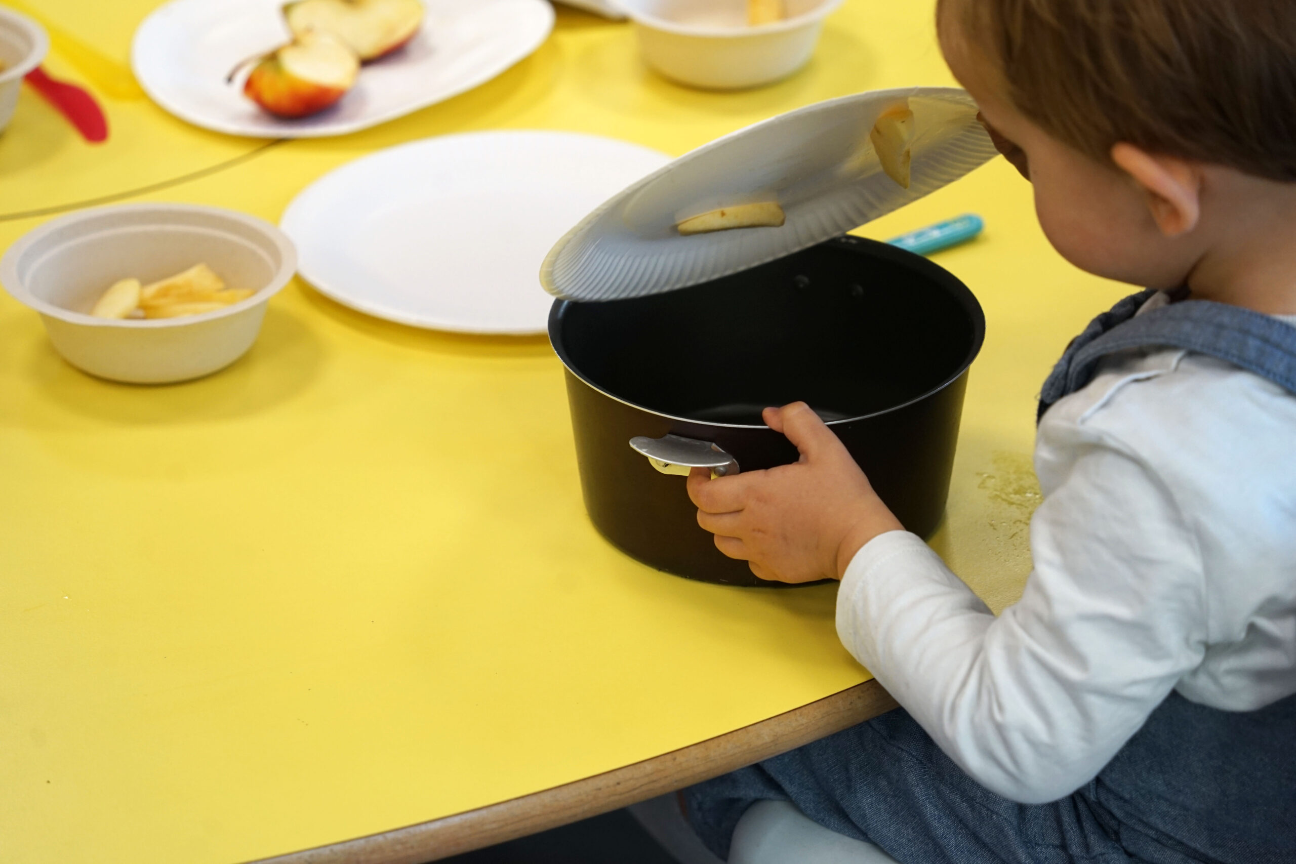 Une éducatrice souriant à un enfant de la crèche