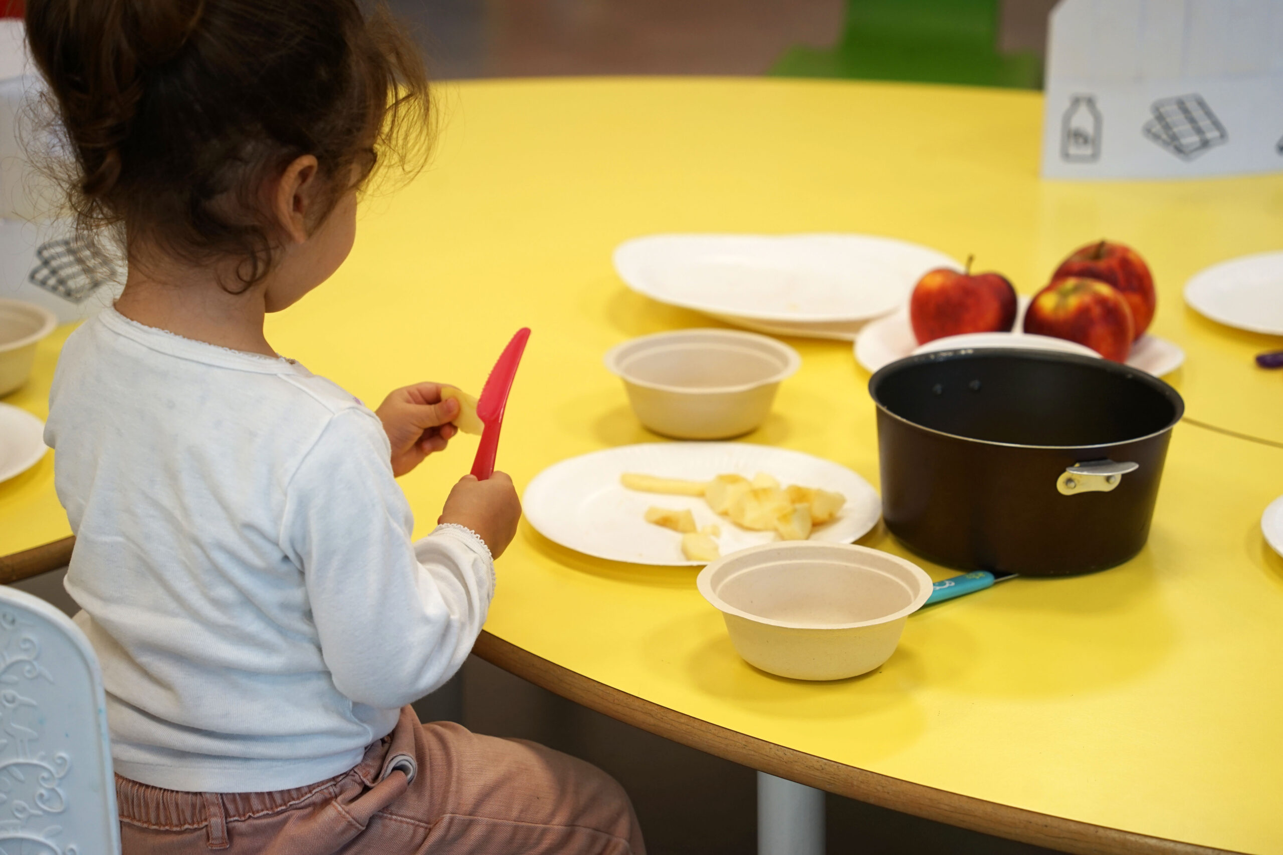Une éducatrice souriant à un enfant de la crèche